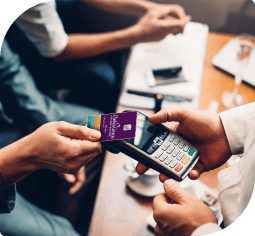 A man's hand taps a Nebula Trust visa card to a touch-free payment system