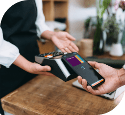 A man's hand uses a Nebula Trust Business Visa debit card in a mobile wallet at a contactless payment system