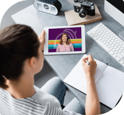 A woman watches ChelseaLIVE on a tablet and takes notes