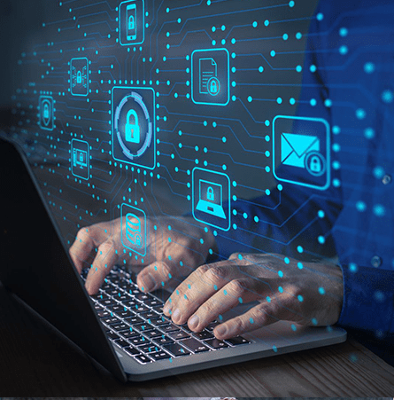 A man types on a laptop with a graphic of blue holographic security icons over his hands