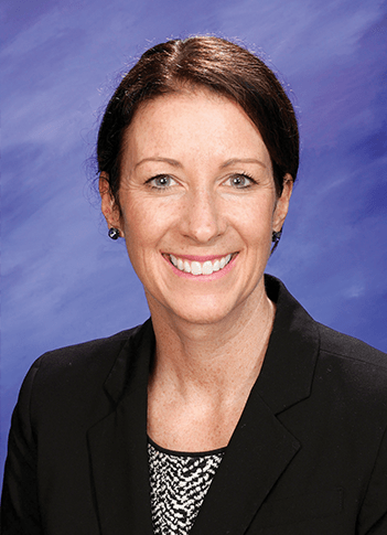 A studio portrait of Kathleen Ringler on a light blue textured background