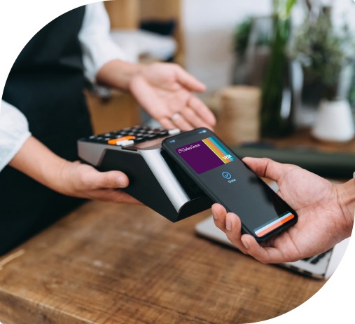 A man's hand uses a Nebula Trust Business Visa debit card in a mobile wallet at a contactless payment system