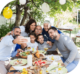 A family of 7 people taking a selfie at a BBQ