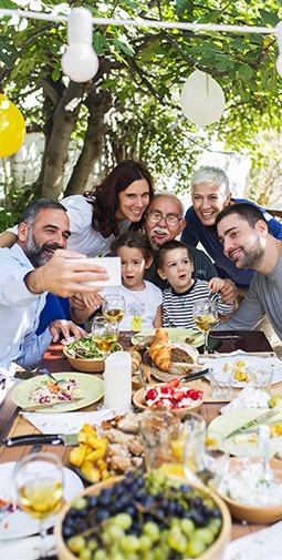 A smiling family of 7 takes a selfie at a barbecue