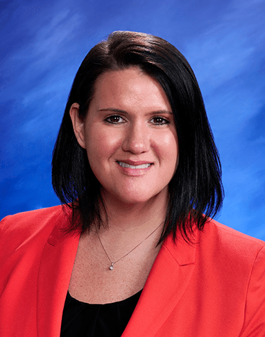 A studio portrait of Rebecca Magner with a bright blue textured background